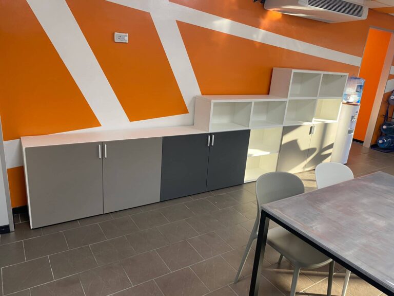 Una mensa aziendale pensata per il comfort quotidiano di chi lavora: sedie Connubia, tavoli Scavolini e una libreria Cinquanta3.